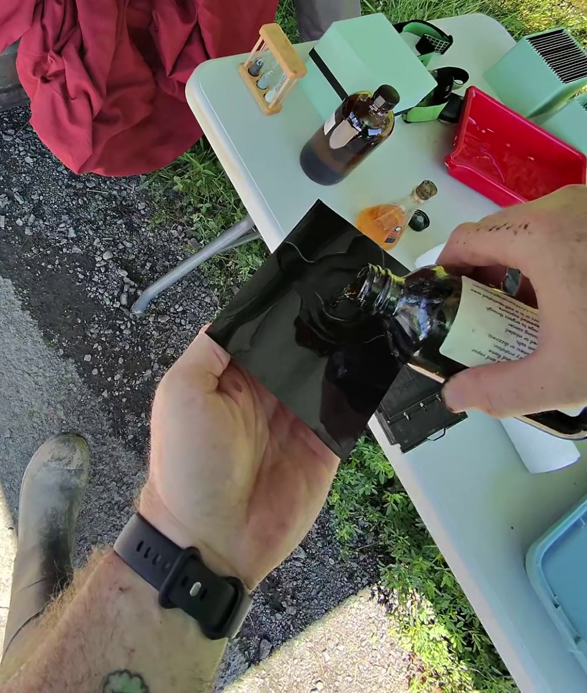 Wet plate photographer pouring collodion onto a metal plate